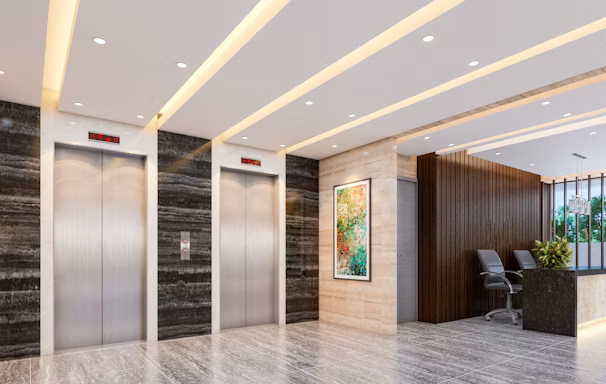 Modern lobby with elevators and reception desk.